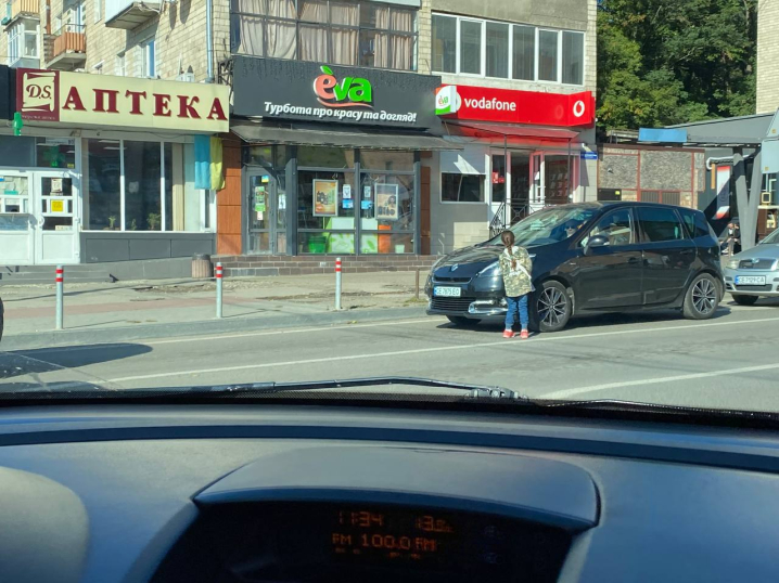 На вулиці Небесної сотні дитина на дорозі миє фари автівок та просить гроші На вулиці Небесної сотні дитина на дорозі миє фари автівок та просить гроші